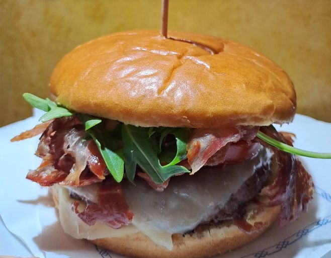 Hamburguesa con pan brioche, jamón, queso y rúcula